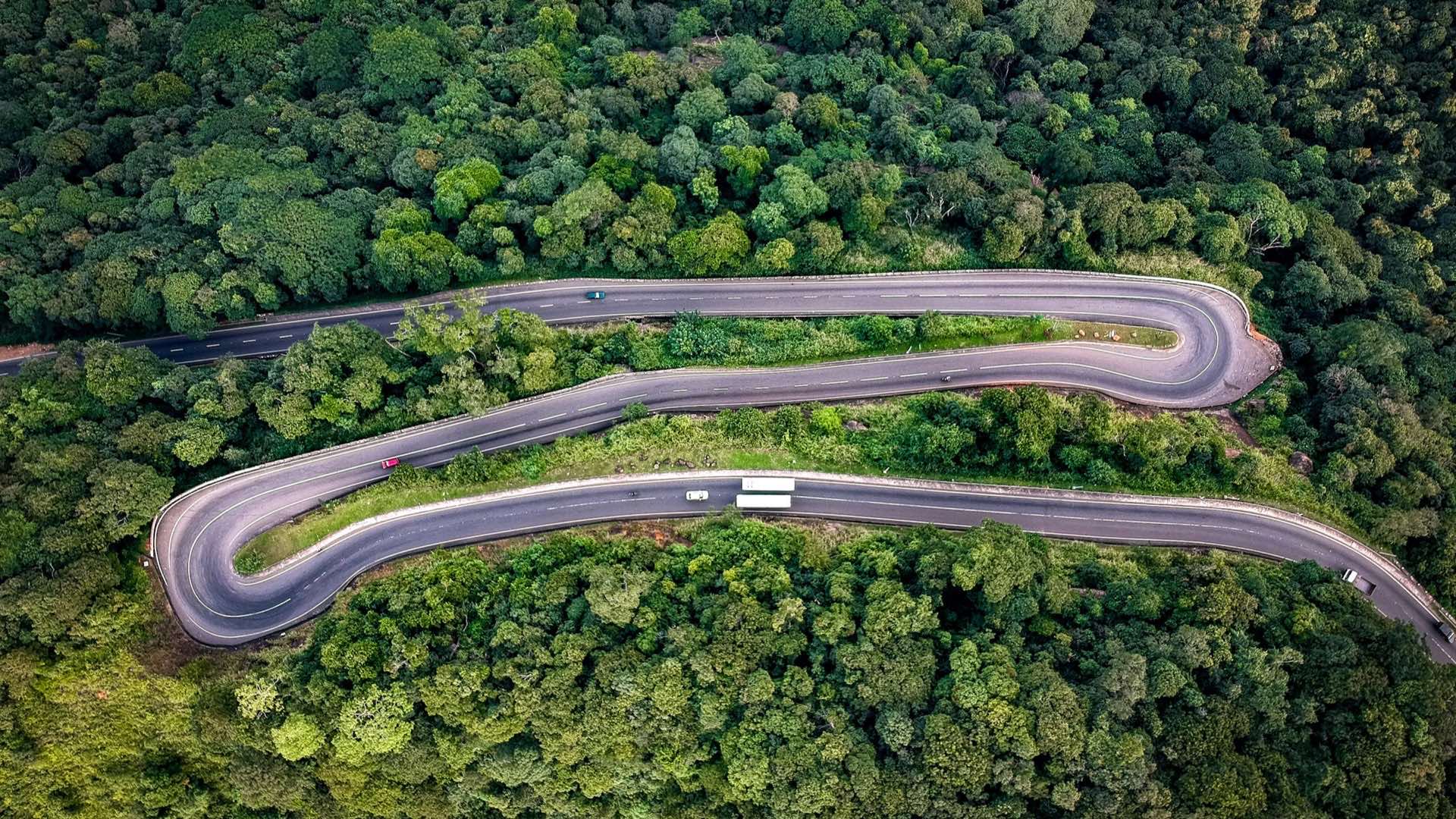 Aerial view of a hairpin road switching back through dense forest on the Kandy–Mahiyangana highway in central Sri Lanka
